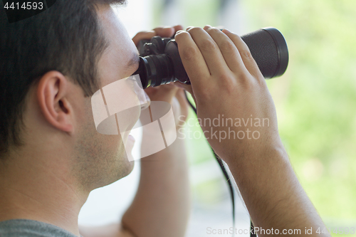 Image of man looking with binoculars