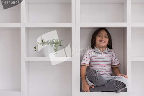 Image of young boy posing on a shelf