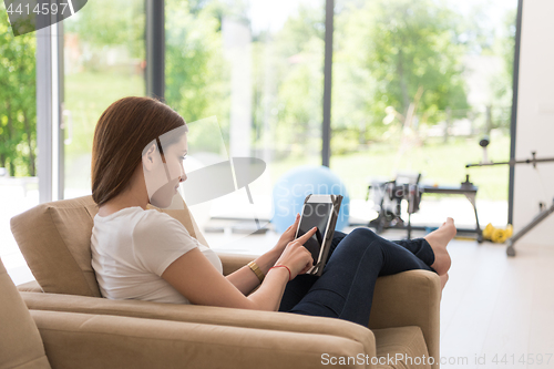 Image of woman sitting on sofa with tablet computer