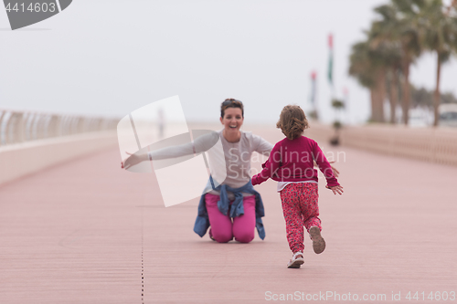 Image of mother and cute little girl on the promenade by the sea