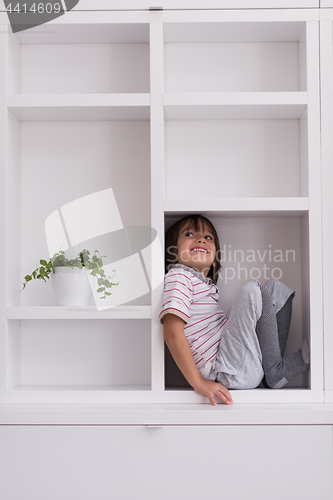 Image of young boy posing on a shelf