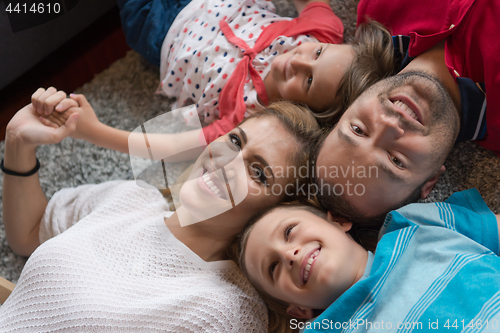 Image of happy family lying on the floor