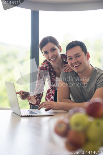 Image of happy young couple buying online