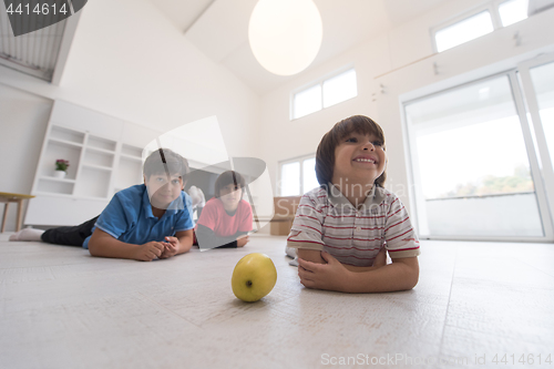 Image of boys having fun with an apple on the floor