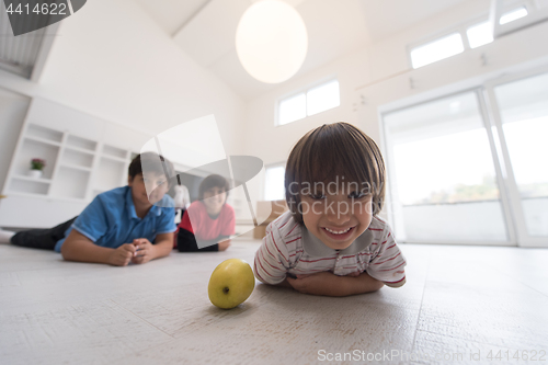 Image of boys having fun with an apple on the floor