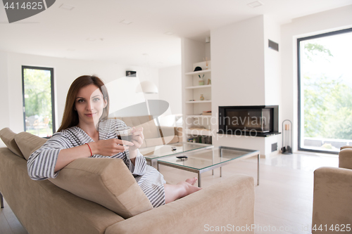 Image of young woman in a bathrobe enjoying morning coffee