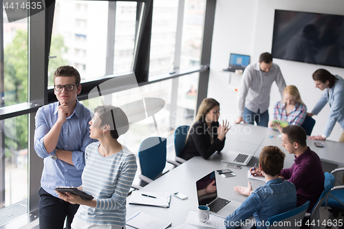 Image of Two Business People Working With Tablet in office