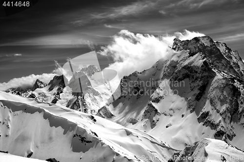 Image of Black and white winter mountains with snow cornice and cloudy sk