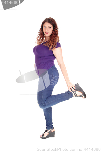 Image of Curvy woman standing in profile with leg up