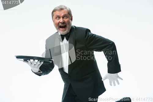 Image of Senior waiter holding tray