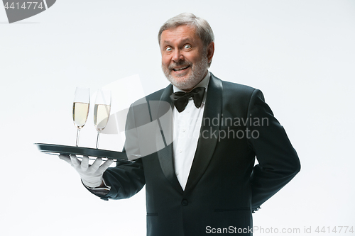 Image of professional waiter in uniform is serving wine