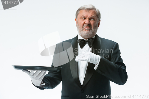 Image of Senior waiter holding tray