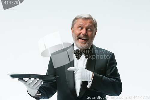 Image of Senior waiter holding tray