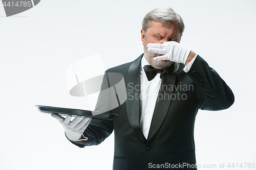 Image of Senior waiter holding tray