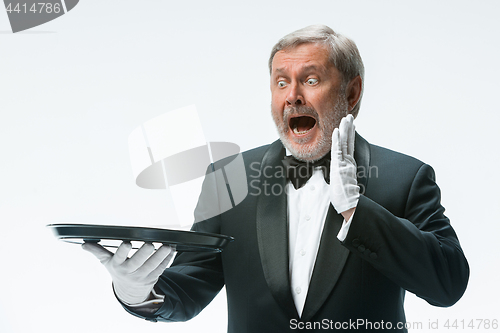 Image of Senior waiter holding tray