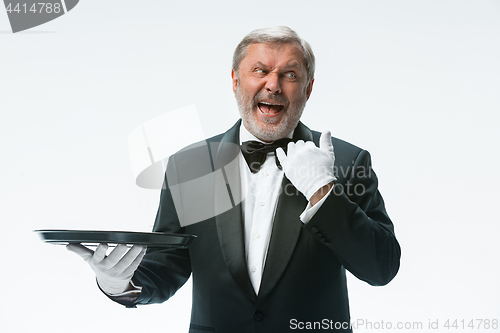 Image of Senior waiter holding tray