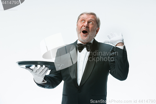 Image of Senior waiter holding tray