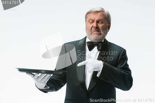 Image of Senior waiter holding tray