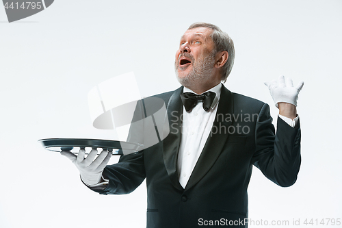 Image of Senior waiter holding tray