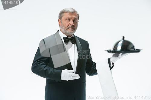 Image of The waiter with tray and metal cloche lid cover