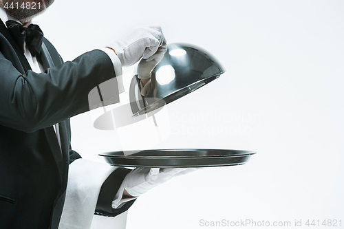 Image of Close up waiter hand with tray and metal cloche lid cover