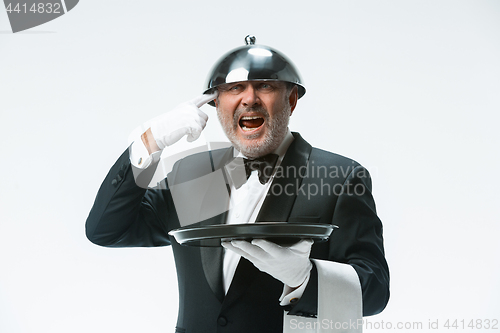 Image of The waiter with tray and metal cloche lid cover