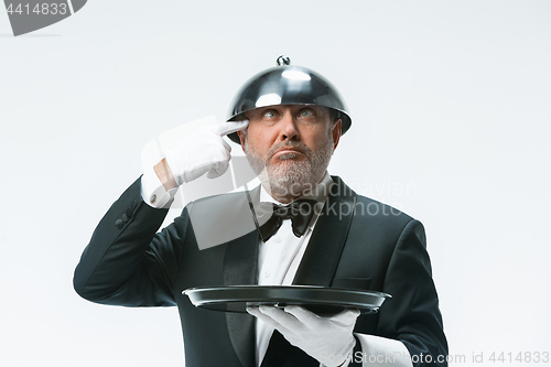 Image of The waiter with tray and metal cloche lid cover