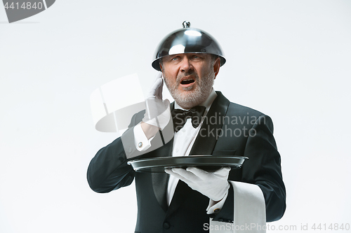 Image of The waiter with tray and metal cloche lid cover