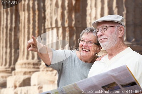 Image of Happy Senior Adult Couple Tourists with Brochure Next To Ancient