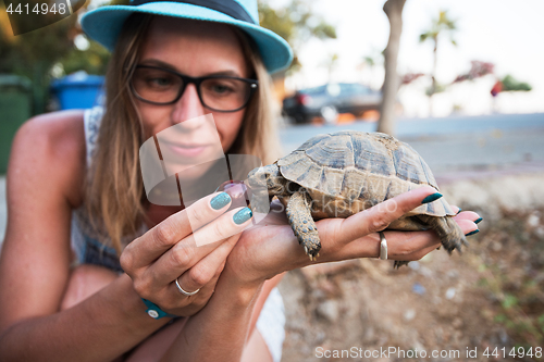 Image of woman feeding turtle