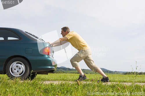 Image of Man pushing his car