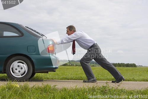 Image of Businessman pushing a car