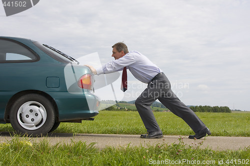 Image of Businessman pushing a car