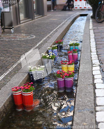 Image of Rubber boots in the water with flowers in the city of Freiburg. Tourist attraction.