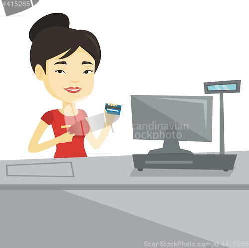 Image of Cashier holding credit card at the checkout.