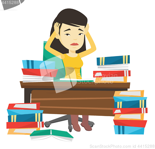 Image of Student sitting at the table with piles of books.