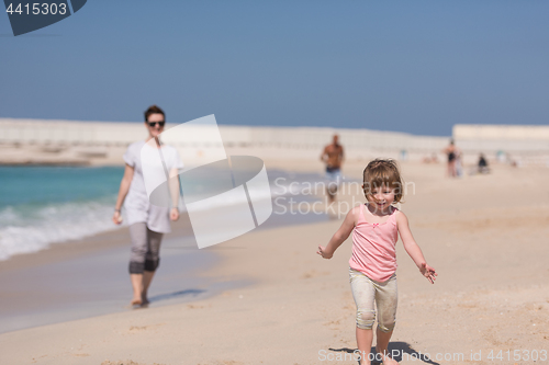 Image of mother and daughter running on the beach