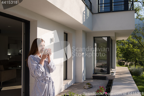 Image of woman in a bathrobe enjoying morning coffee