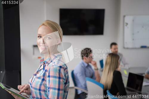 Image of Pretty Businesswoman Using Tablet In Office Building by window