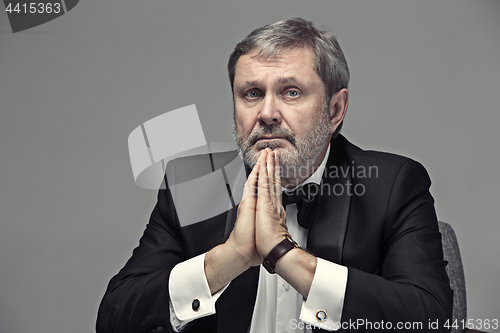 Image of Senior Businessman sitting in chair