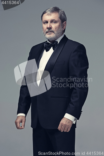 Image of Middle aged male adult wearing a suit isolated on gray