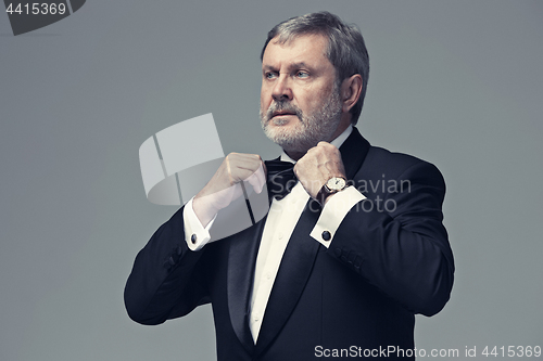 Image of Middle aged male adult wearing a suit isolated on gray