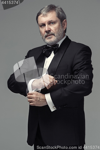 Image of Middle aged male adult wearing a suit isolated on gray