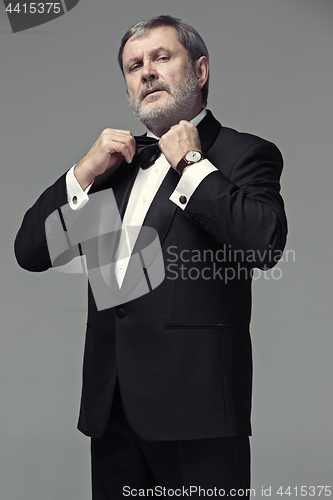 Image of Middle aged male adult wearing a suit isolated on gray