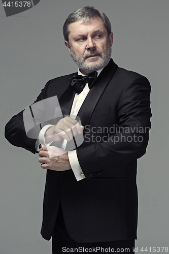 Image of Middle aged male adult wearing a suit isolated on gray