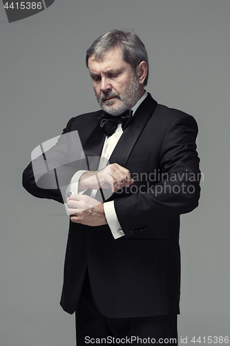 Image of Middle aged male adult wearing a suit isolated on gray