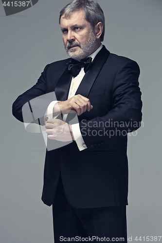 Image of Middle aged male adult wearing a suit isolated on gray