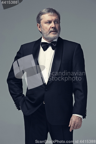 Image of Middle aged male adult wearing a suit isolated on gray