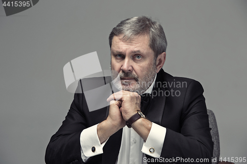 Image of Senior Businessman sitting in chair