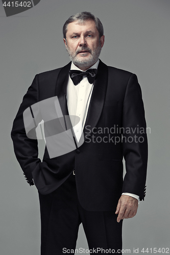 Image of Middle aged male adult wearing a suit isolated on gray